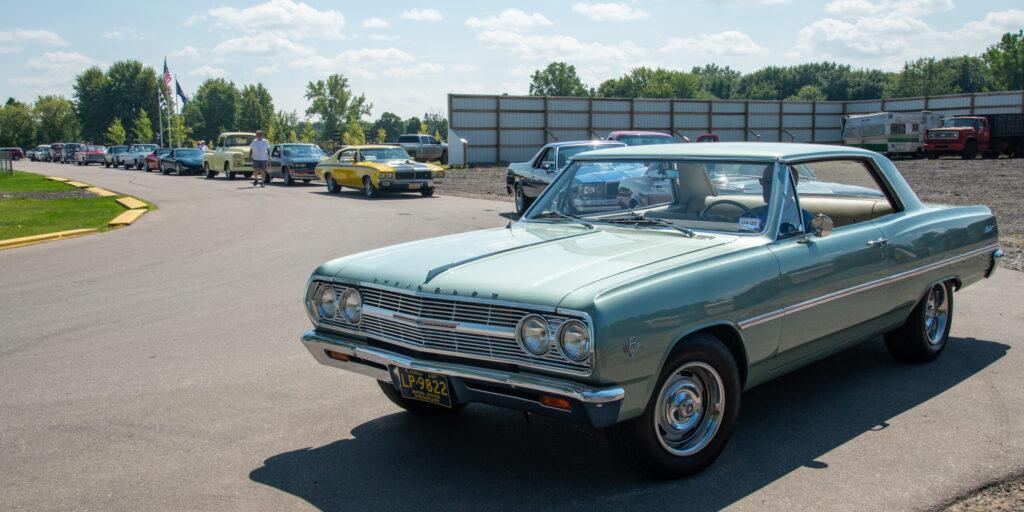 Classic light blue vintage car parked outdoors on a sunny day.