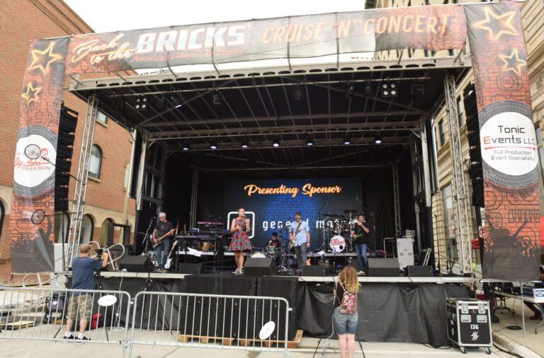 A live band performs on an outdoor stage at Bricks Music Concert.
