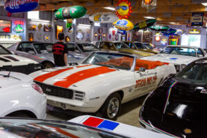 Classic white and orange race car displayed indoors with vintage decor.