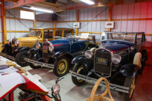 Three vintage cars displayed in a museum setting.