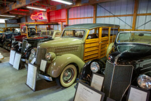 Classic vintage wood-paneled station wagon in an indoor car exhibit.