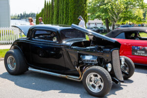 Classic black hot rod car displayed at an outdoor event.