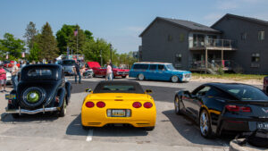 Yellow sports car parked among other vehicles in a sunny lot.