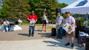 People gather outdoors for a casual event on a sunny day.