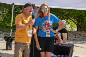 Two people engaging in a lively conversation at an outdoor event.