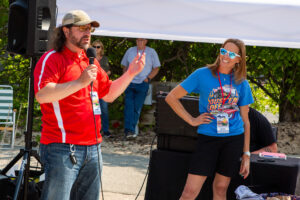 Two people engaged in a lively outdoor conversation, one holding a microphone.