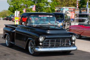 Classic black vintage pickup truck parked outdoors on a sunny day.