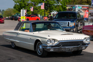 Classic white Ford Thunderbird parked on a sunny street.