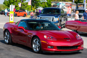 A shiny red sports car parked on a sunny street.