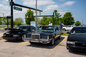 Classic black Lincoln Town Car parked among other cars on a sunny day.