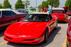 Red Chevrolet Corvette sports car parked at a car show.