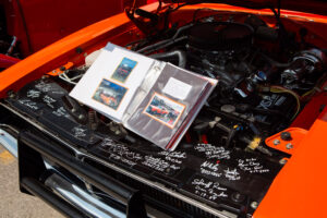 Car engine with handwritten notes and photo album on the hood.