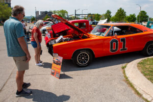 Classic cars displayed at an outdoor car show with spectators.