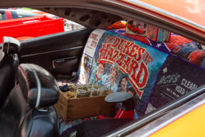 A car interior decorated with a colorful Dukes of Hazzard blanket and various items.