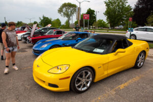 A vibrant yellow sports car parked among other colorful vehicles at a car show.