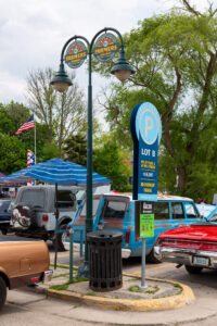 Classic cars displayed at an outdoor car show on a sunny day.