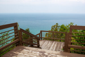 Wooden stairs leading down to a scenic ocean view.