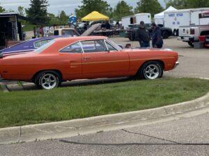 Classic red muscle car parked at an outdoor event.