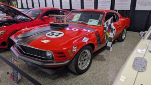 Classic red Ford Mustang race car with number 57 on the hood and doors.