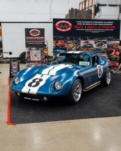 A classic blue and white race car displayed indoors.