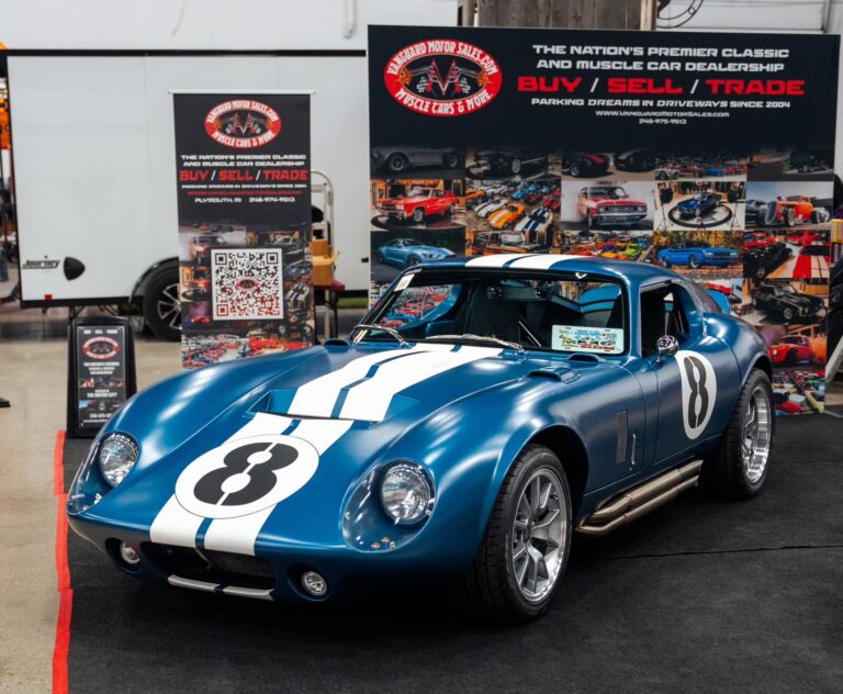 A classic blue and white race car displayed indoors.