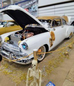Classic car decorated for Halloween with skeleton and spooky accents.