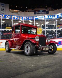Classic red vintage pickup truck displayed indoors at an event.