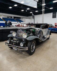 Classic vintage car displayed indoors at a car show.