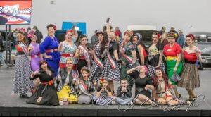 A lively group of performers in colorful costumes on stage.