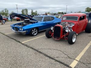 A vibrant blue muscle car and a classic red hot rod parked side by side.
