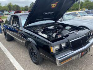 Classic black Buick Grand National with hood open showing engine.