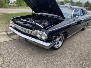 Classic black vintage car with hood open, showcasing engine.