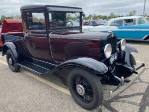 Classic vintage car parked outdoors with polished maroon and black paint.