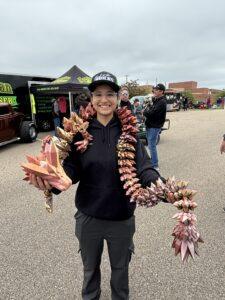 Person holding large clusters of crawfish at an outdoor market.