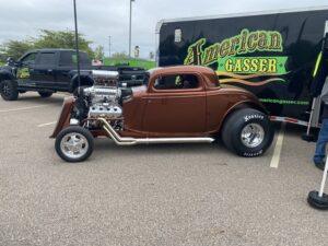 Classic hot rod car with exposed engine and vintage design.