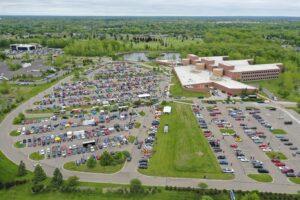 Aerial view of a crowded shopping mall parking lot on a clear day.