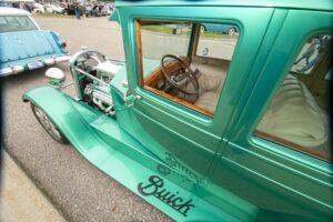 Classic green Buick vintage car with a wooden steering wheel.