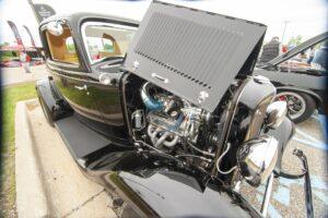 Classic car with open hood showing detailed engine.
