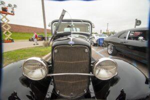Classic vintage car with round headlights and chrome details.