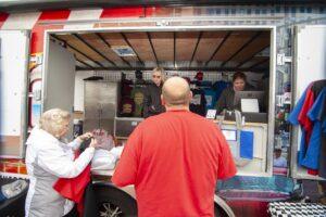 People ordering food from a vendor truck inside a garage.