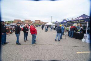 People milling around an outdoor market or fair on a cloudy day.