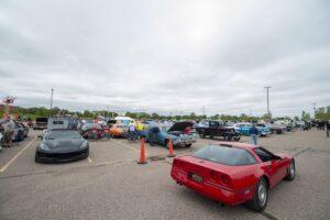 A parking lot filled with various sports cars under a cloudy sky.