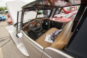 Interior of a vintage car with brown seats and a wooden dashboard.