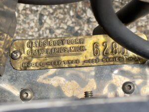 Close-up of a metal plate with manufacturing details and a serial number.