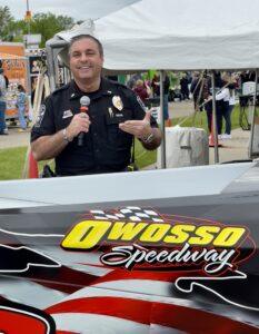 A police officer speaking at Owosso Speedway event.