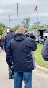 People wearing dark jackets walking outdoors near food trucks.