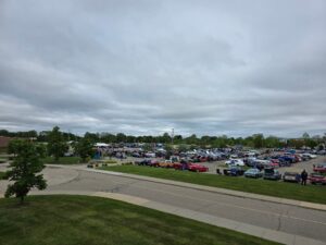 A large parking lot filled with cars under a cloudy sky.