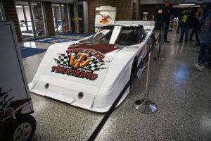 A sleek white drag racing car with bold graphics and sponsor logos.