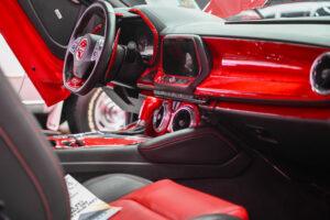Sleek red and black modern car interior with advanced dashboard and steering wheel.