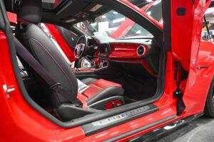 Sleek red sports car interior with black and red leather seats.